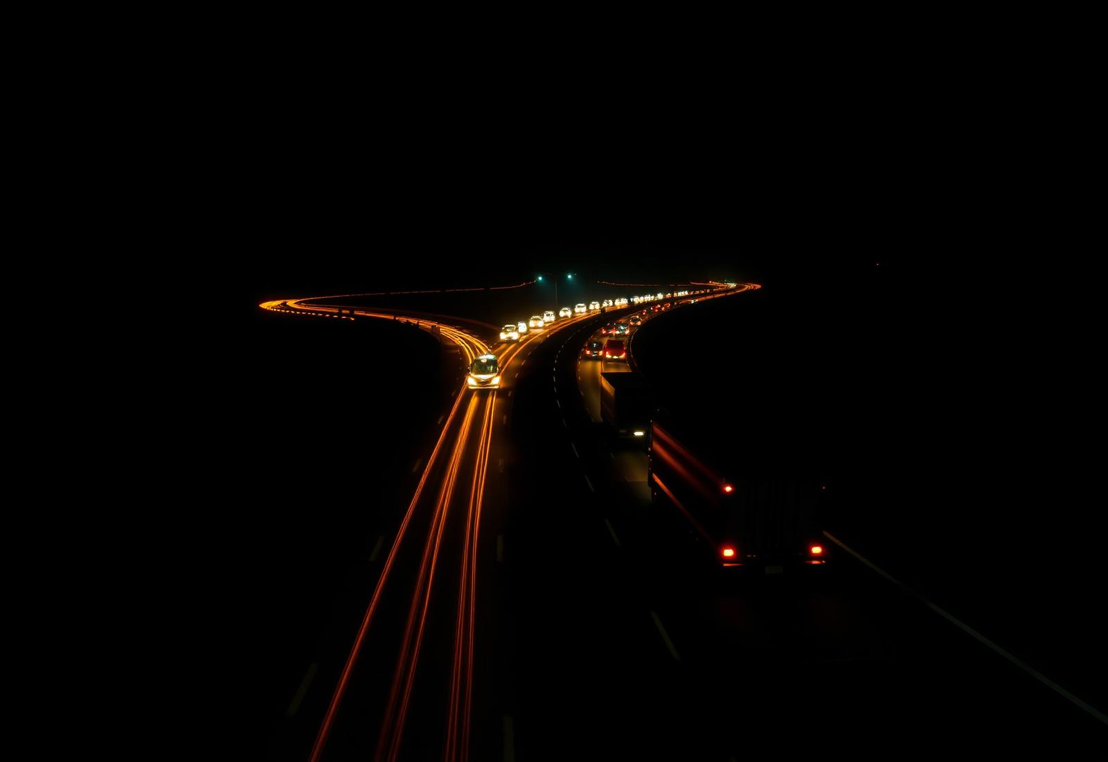 Carretera nocturna en México con camiones de carga en movimiento